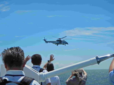 体験航海中、接近したヘリコプターに手を振る様子画像