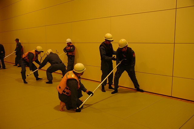 受講者が刺叉を使い犯人役を壁に押さえつけている様子