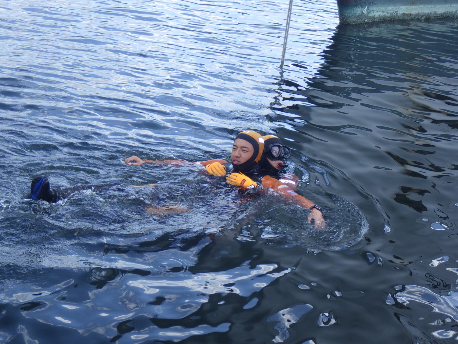 海上で潜水士が要救助者を運搬している様子