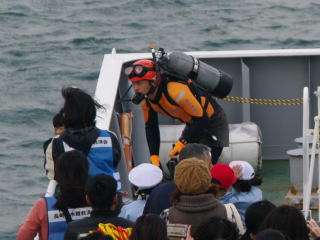 海面に飛び込む準備をする潜水士