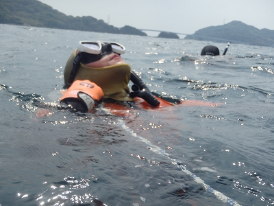 10キログラムの錘を保持して立ち泳ぎをしている潜水士