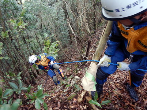 山の急斜面を降りる潜水士