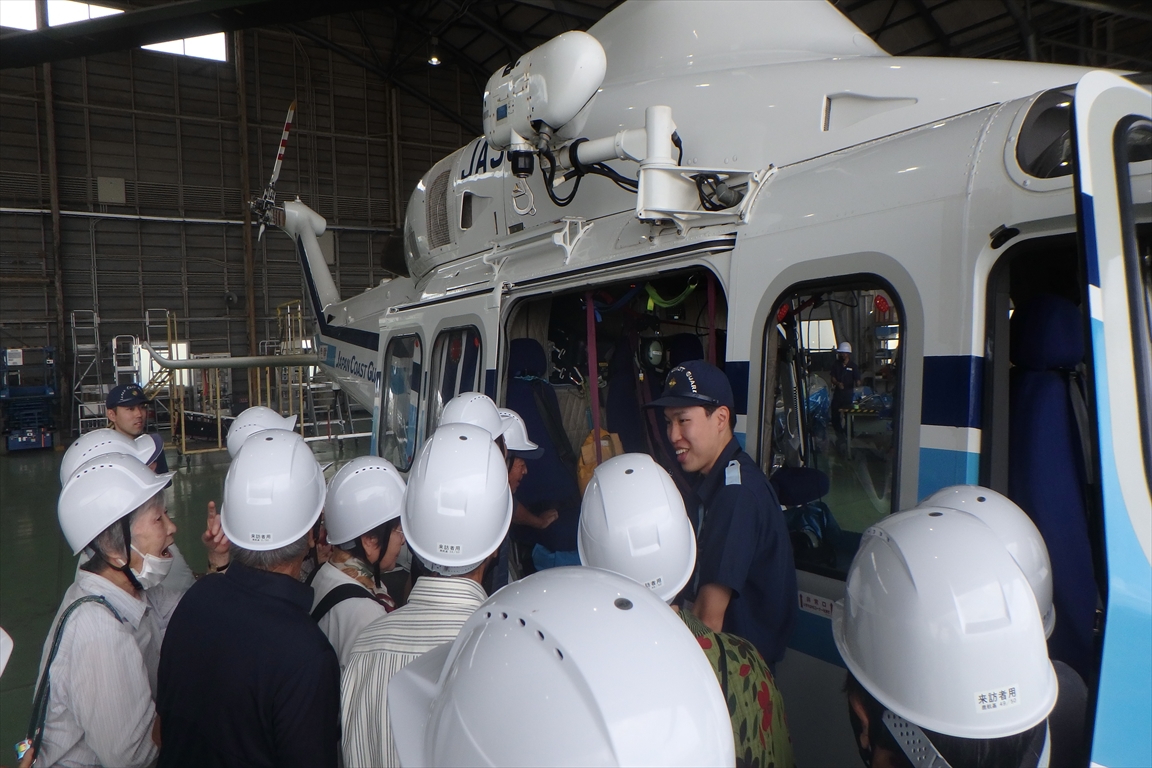 見学者に対してヘリコプターの機体説明を実施している職員及び説明を受けている見学者の写真