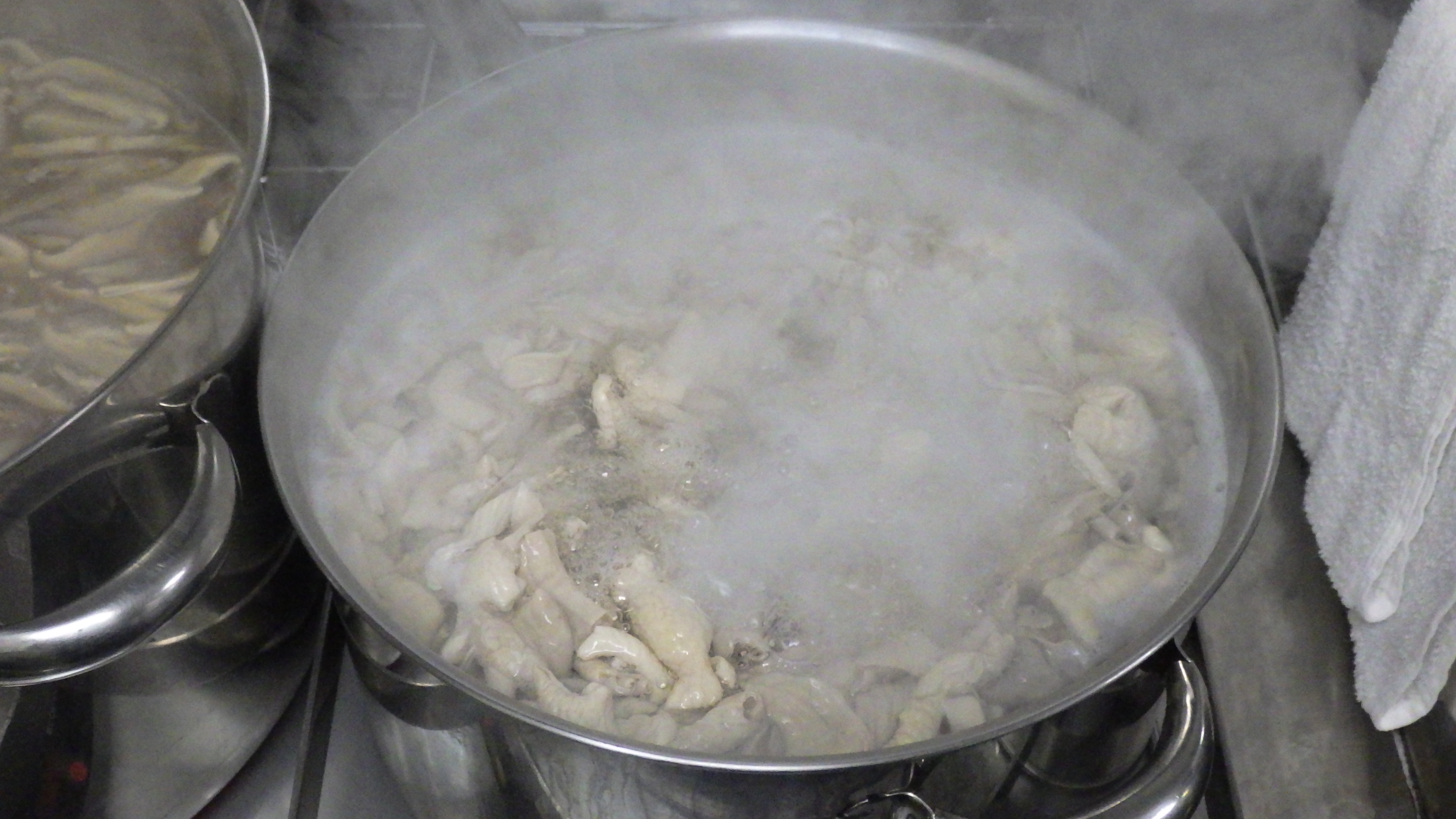 豚の中身を鍋でゆでている様子