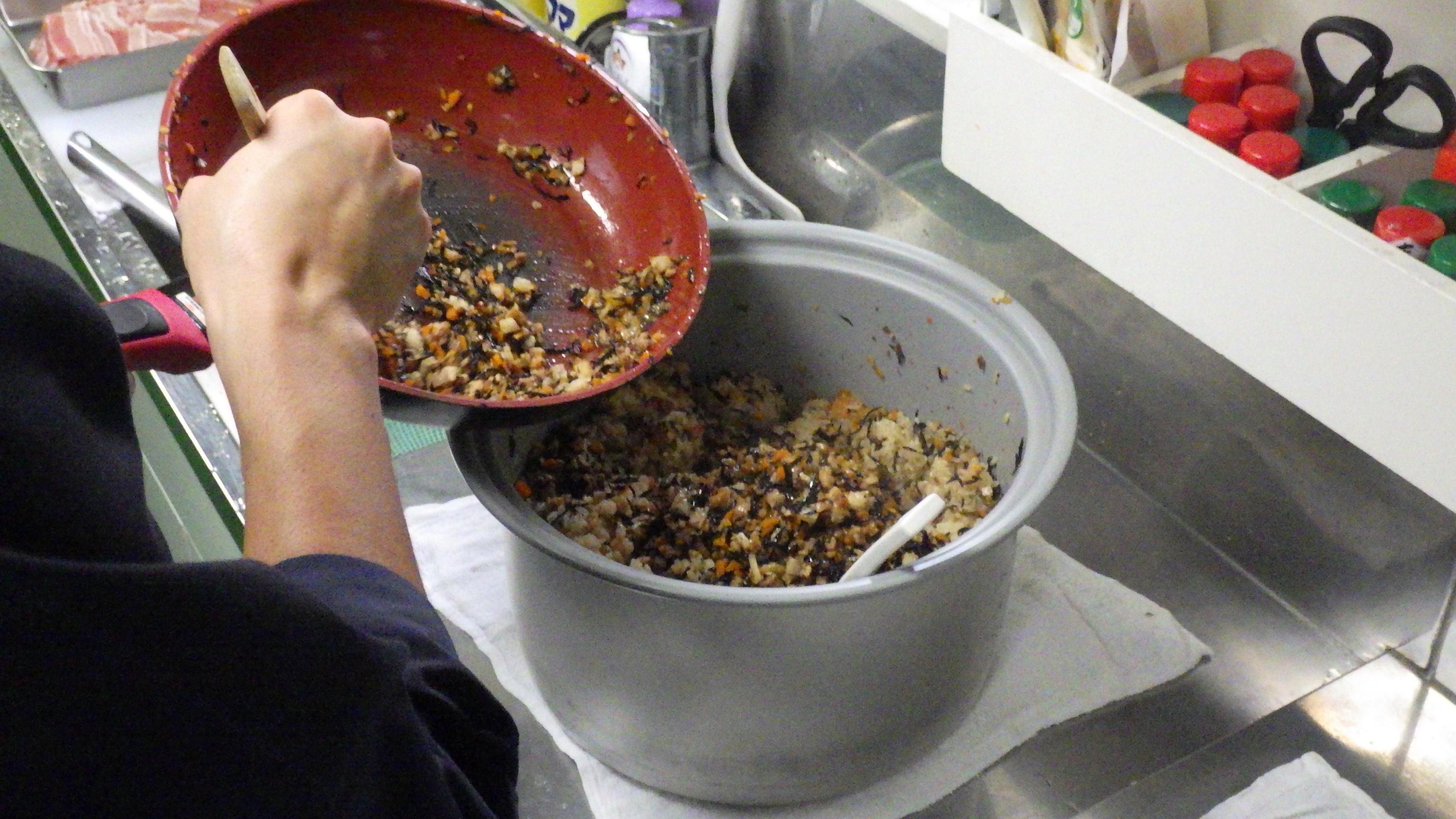 炊いた米と炒めた具材を混ぜる様子