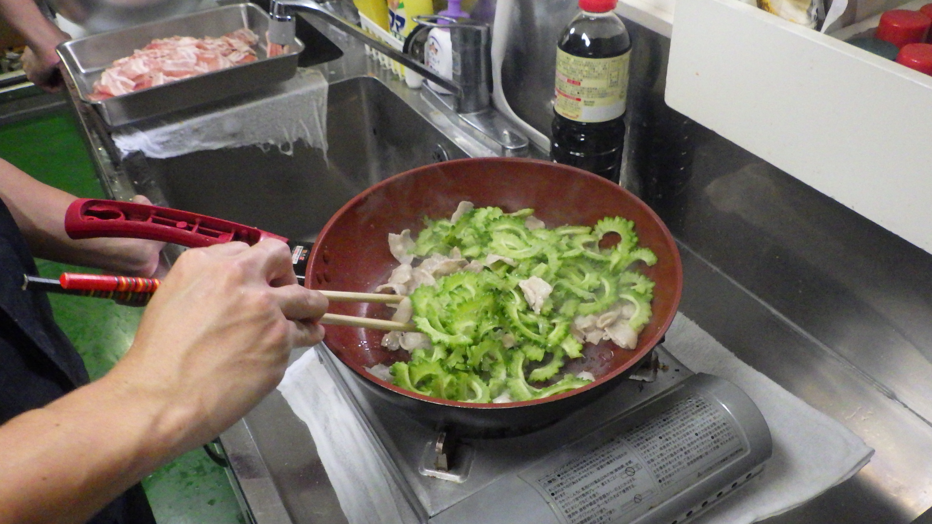 豚バラとゴーヤを炒める様子